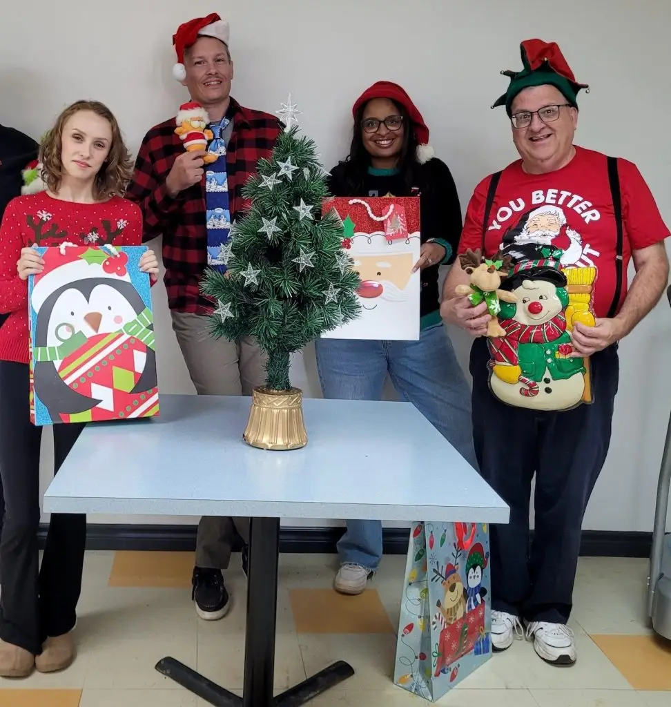 Collègues festifs autour d’un petit sapin de Noël